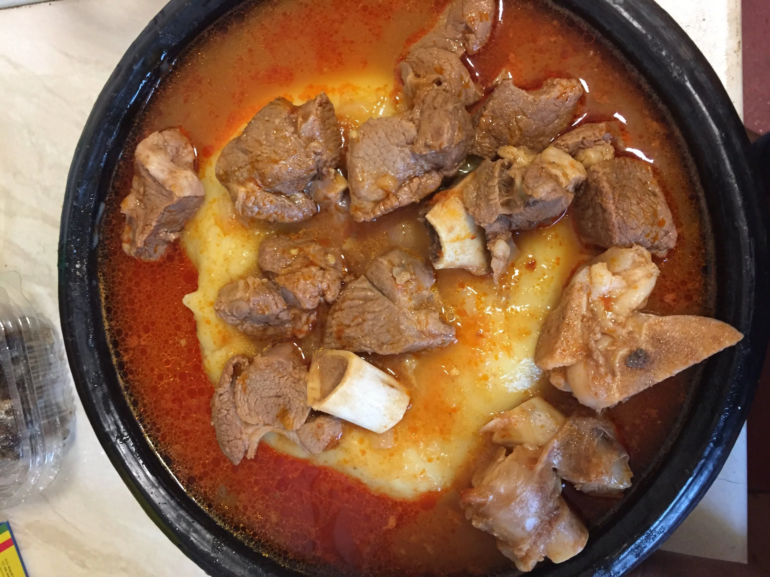 Ghanaian cassava fufu, light soup, with goat meat meat and tilapia